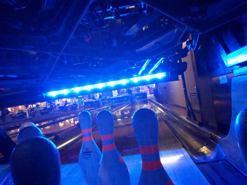 Photo - from behind the pins looking up the bowling lane blue LED light